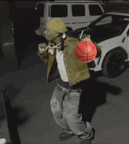 a man holding a basketball in front of a white suv