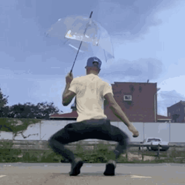 a man is holding a clear umbrella while standing on the ground .