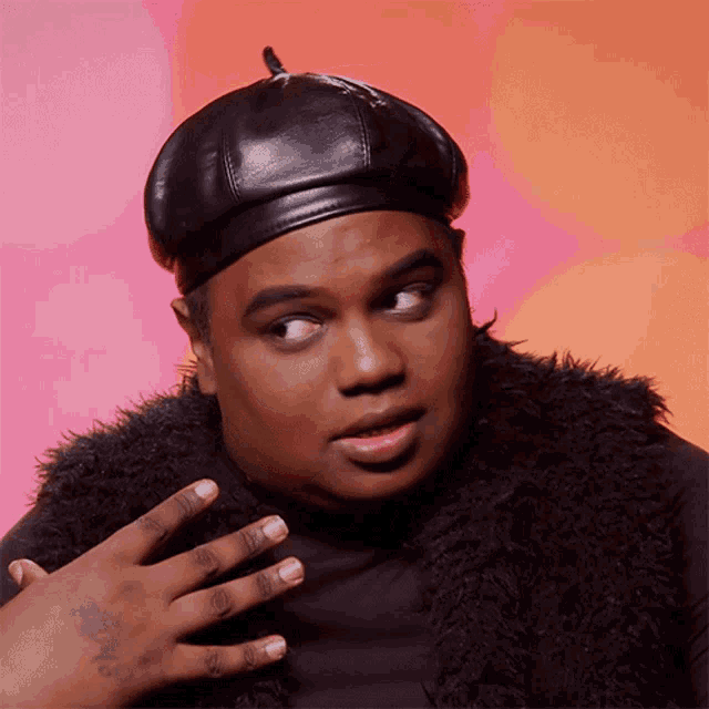 a man wearing a black hat and a fur vest has a tattoo on his wrist that says " i love you "
