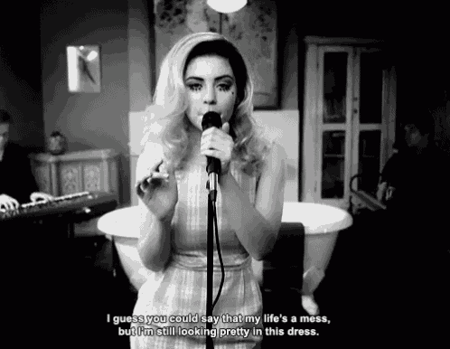 a woman singing into a microphone with the words i guess you could say that