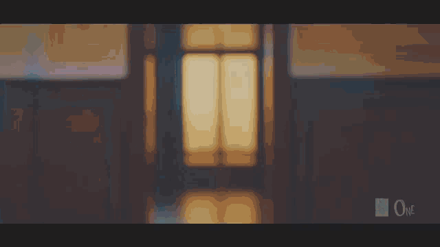 two young women are standing next to each other in front of a window in a dark room .