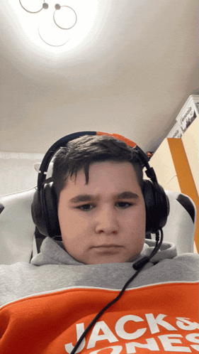a young boy wearing headphones and a jack & jones sweatshirt