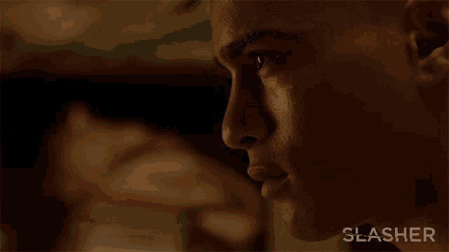 a close up of a man 's face with the word slasher on the bottom right