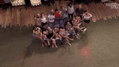 a group of people are posing for a picture while sitting on a couch in a room .