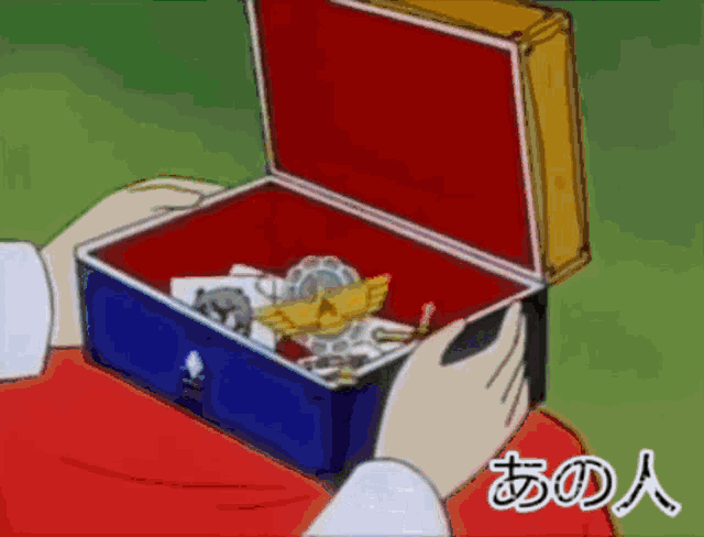 a person holding a blue box with a red velvet lid