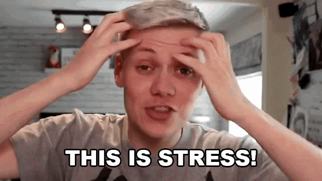 a young man with his hands on his head says this is stress