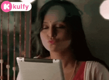 a woman is blowing a kiss while looking at a tablet