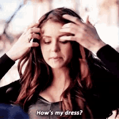 a woman is getting her hair done by a man and asking how 's my dress .