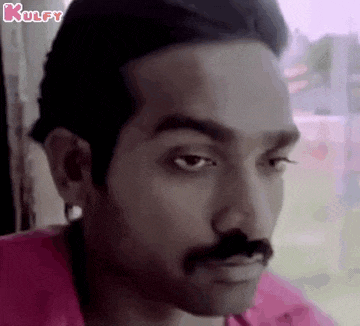 a man with a mustache is making a funny face .