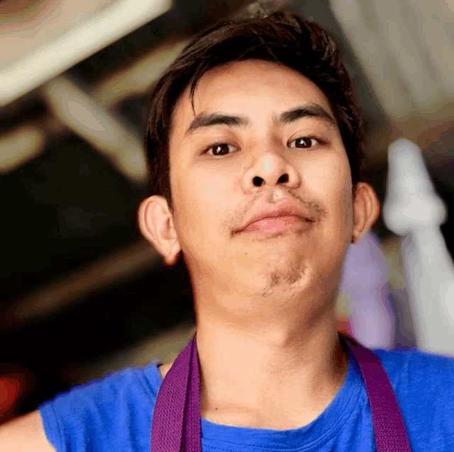 a man wearing a blue shirt and a purple apron