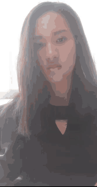 a close up of a woman 's face with long hair and a black shirt .