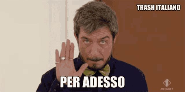 a man wearing a bow tie says per adesso in a foreign language