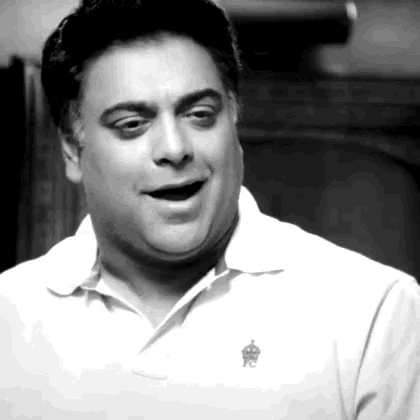 a black and white photo of a man wearing a white polo shirt with a crown on it
