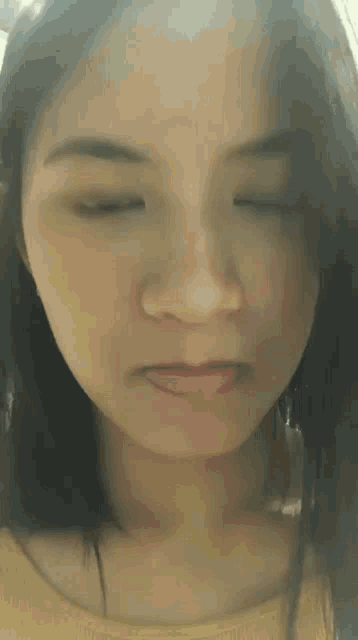 a close up of a woman making a face with her eyes closed