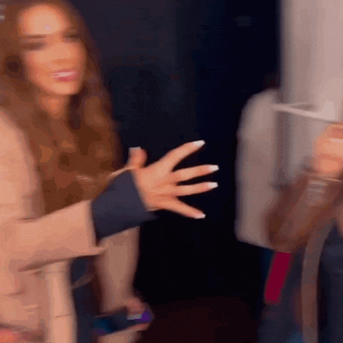 a blurry picture of a woman 's hand reaching out towards another woman 's hand .