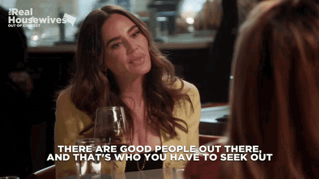a woman is sitting at a table with a glass of wine and the words " there are good people out there " are displayed