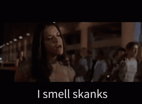 a woman is standing in front of a crowd of people and saying `` i smell skanks '' .