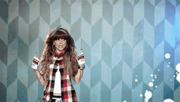 a woman in a plaid shirt is standing in front of a wall
