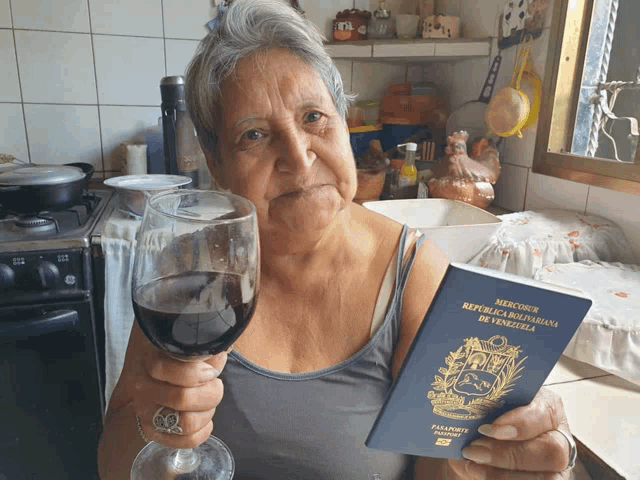 a woman is holding a glass of wine and a passport from venezuela