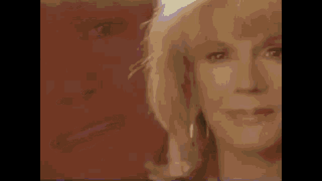 a close up of a woman 's face with blonde hair and a red background
