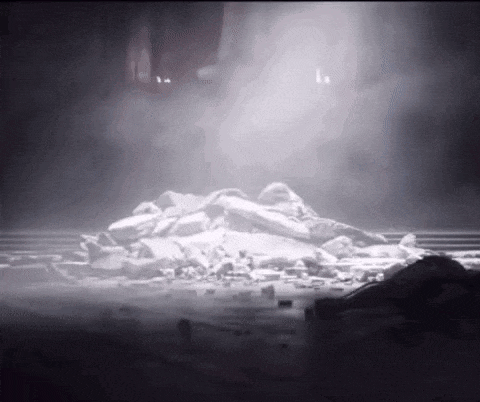 a pile of rocks is sitting on the ground in a dark room with smoke coming out of it .