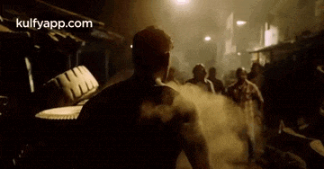 a man is standing in front of a crowd of people in a dark room .