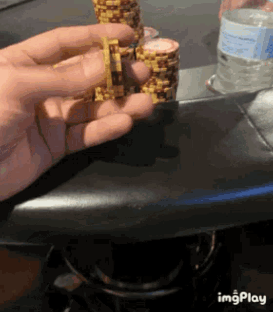 a person is holding a pile of poker chips in their hand .