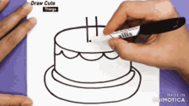a person is drawing a cake with a marker