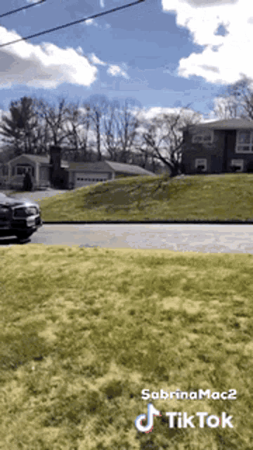 a car is parked on the side of the road next to a grassy hill