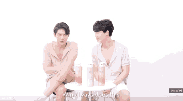 two young men are standing next to each other and talking .