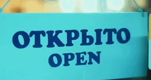 a blue sign that says " открыто open " in black letters