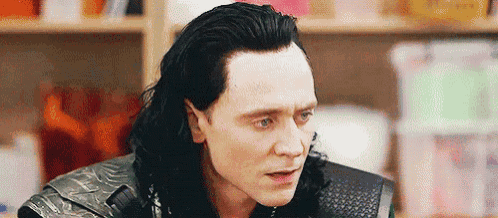 a close up of a man 's face with long black hair .