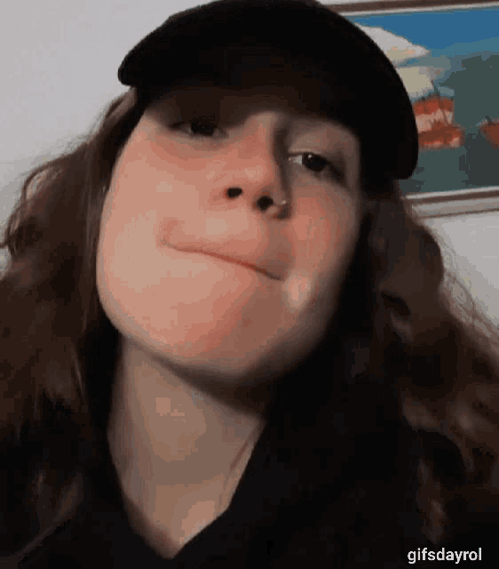 a close up of a woman wearing a hat and making a face