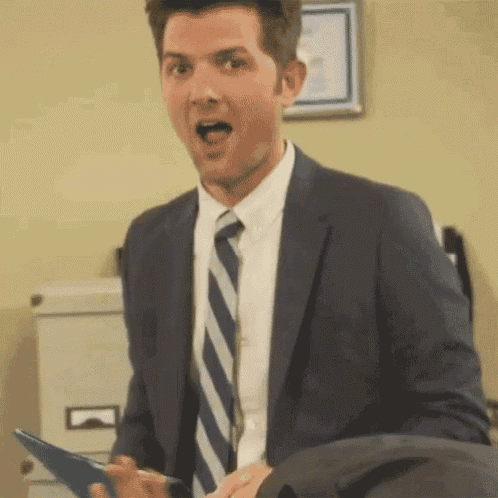 a man in a suit and tie is holding a clipboard in his hand .