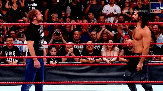 two wrestlers are standing in a wrestling ring with a crowd watching and a banner that says austin 3:16
