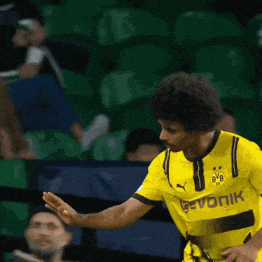 a soccer player wearing a yellow jersey with bvb on the front