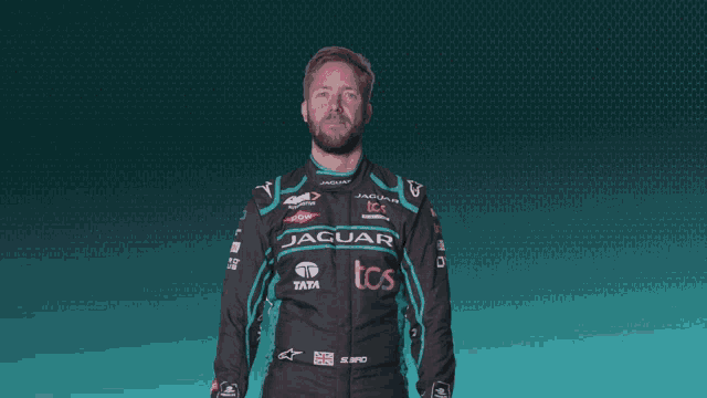 a man in a jaguar tcs racing suit dancing