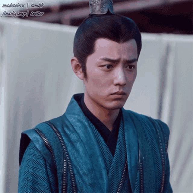 a man with a crown on his head is wearing a blue robe
