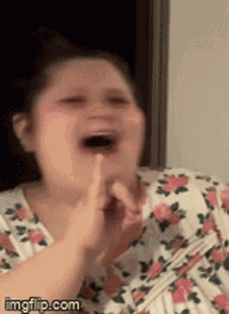 a woman in a floral shirt is clapping her hands
