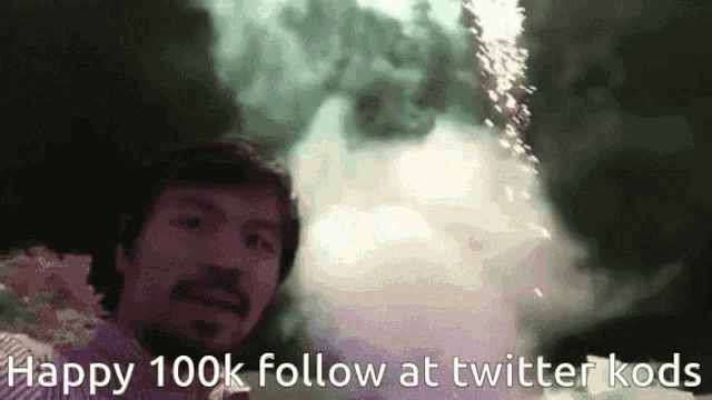a man is standing in front of a fireworks display with the words happy 100k follow at twitter kods below him