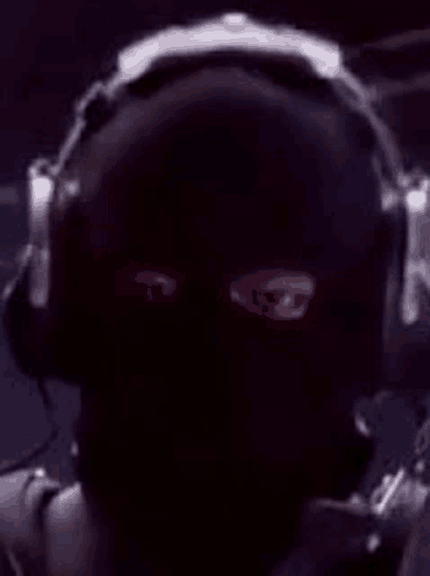 a man wearing a mask and headphones with red eyes .