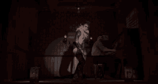 a man is playing a piano while a woman is dancing
