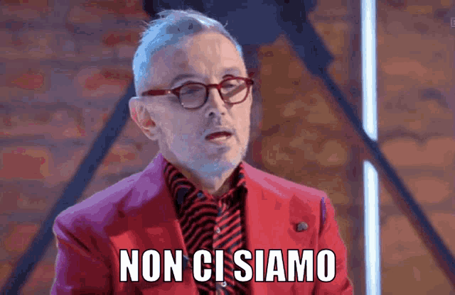 a man with glasses and a red suit says non ci siamo