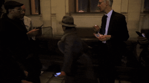 a man in a suit and tie stands next to a woman in a hat and the words tenez vous bien