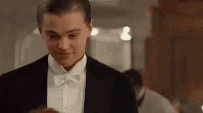 leonardo dicaprio is wearing a tuxedo and bow tie and smiling .