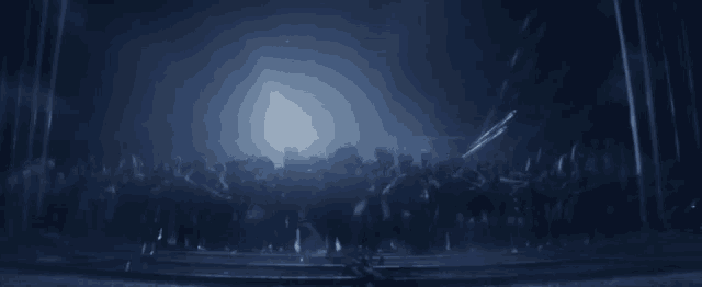 a blurred image of a crowd of people dancing in a dark room .