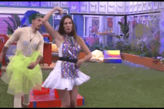 a man and a woman are dancing in front of a building
