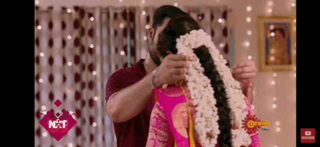 a man is putting flowers in a woman 's hair