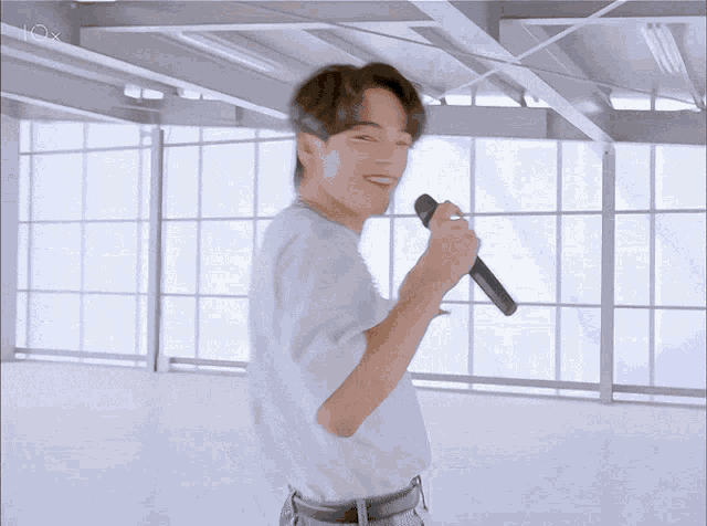 a man in a white shirt holds a microphone in his hand