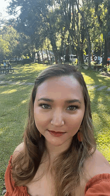 a woman taking a selfie in front of a park